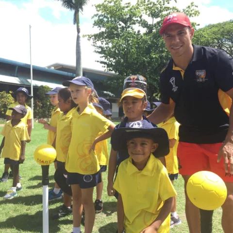 David Mead smiling with children during a sports workshop