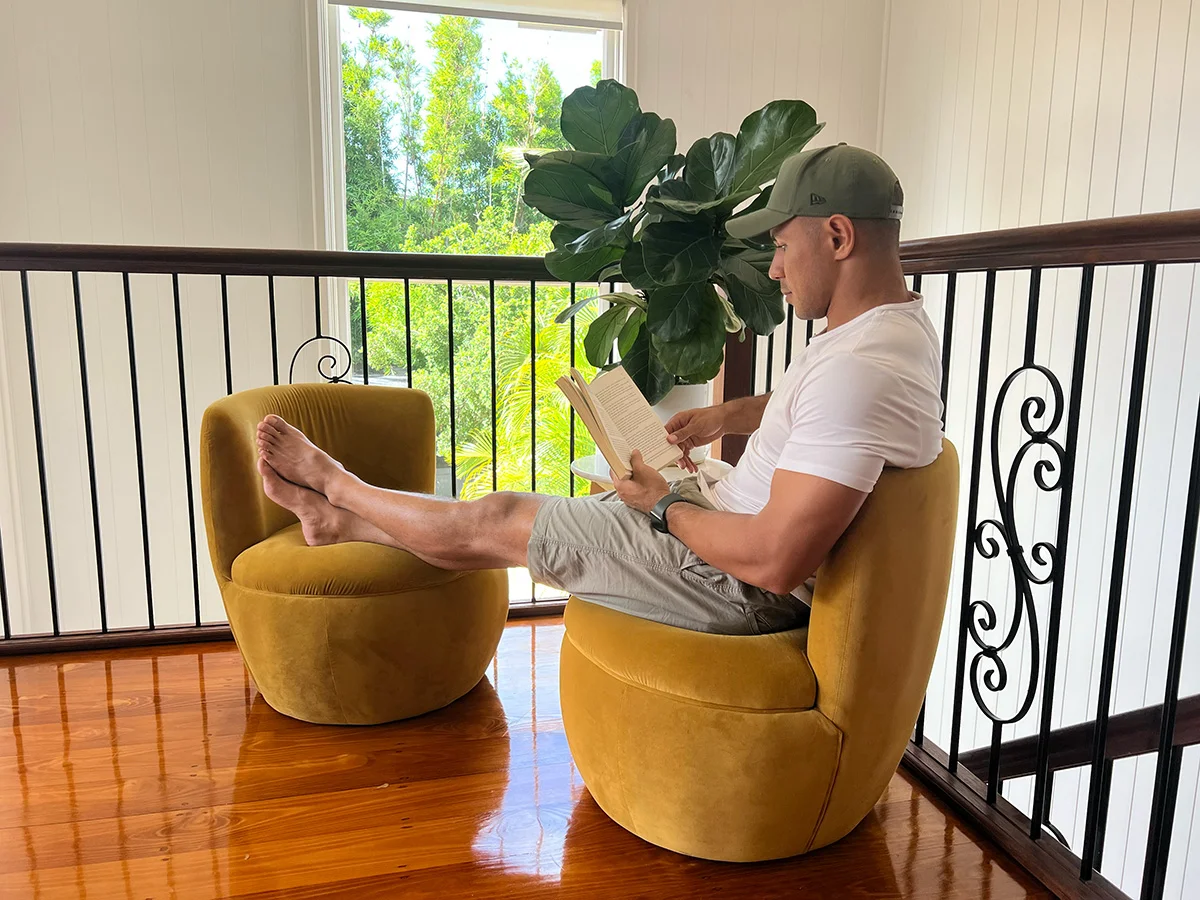 David Mead sitting in yellow chair reading a book